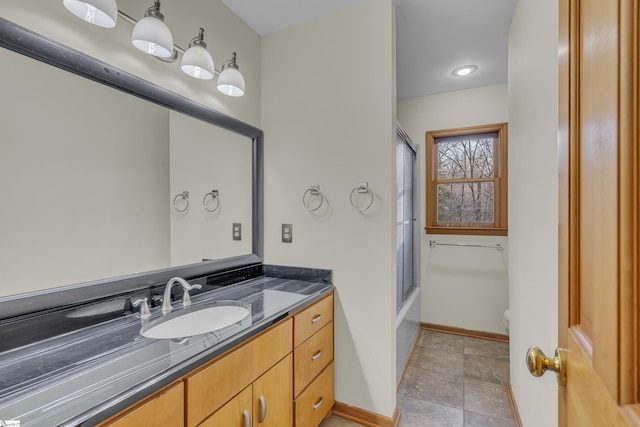 full bathroom featuring enclosed tub / shower combo, vanity, and toilet