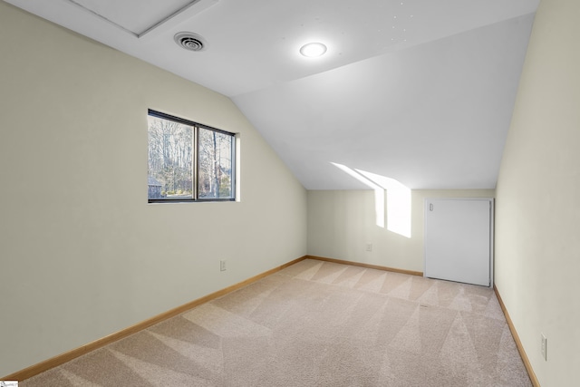 additional living space with vaulted ceiling and light colored carpet