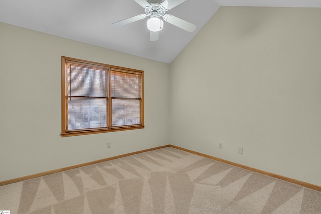 carpeted spare room featuring lofted ceiling and ceiling fan