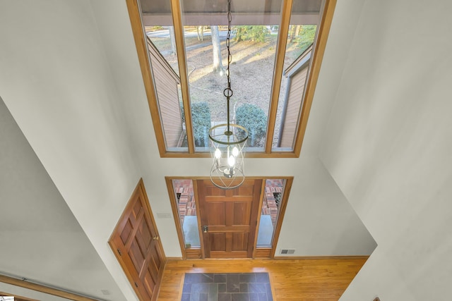 foyer entrance featuring a high ceiling, hardwood / wood-style floors, and an inviting chandelier