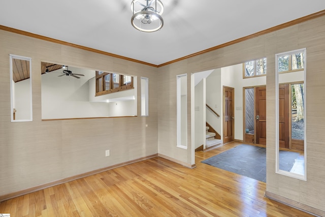 interior space with ornamental molding, hardwood / wood-style floors, and a notable chandelier