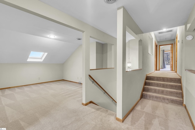 bonus room with vaulted ceiling with skylight and light colored carpet