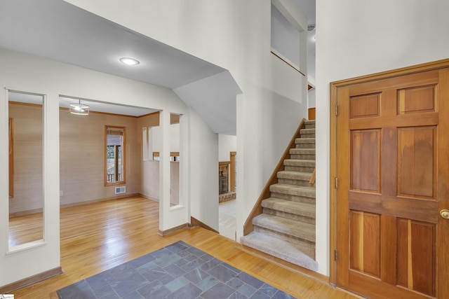 foyer featuring hardwood / wood-style flooring and a brick fireplace