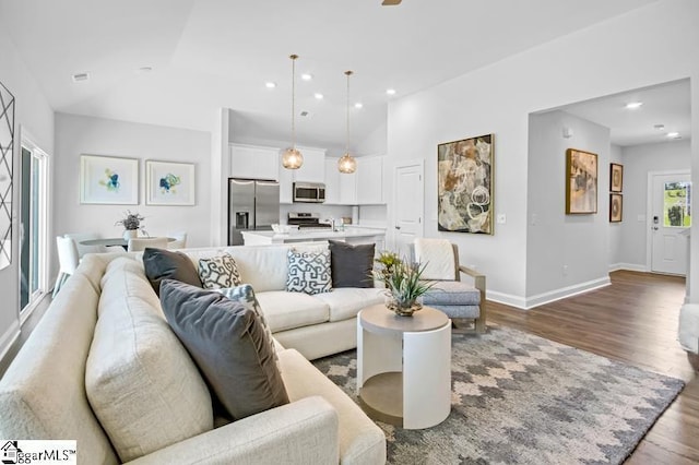 living room featuring dark wood-type flooring and high vaulted ceiling