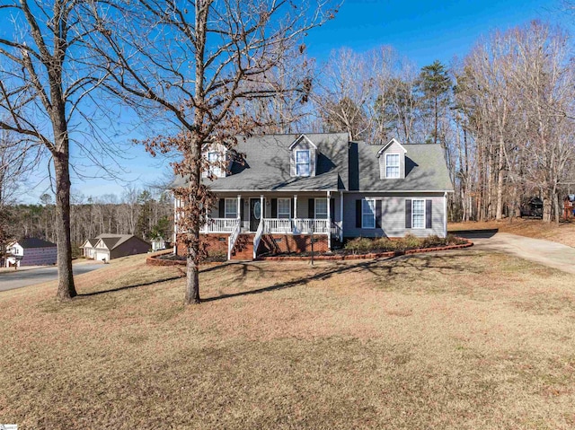 new england style home with covered porch and a front lawn