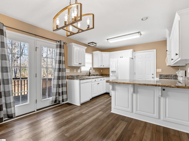 kitchen featuring sink, white cabinetry, decorative light fixtures, kitchen peninsula, and white appliances