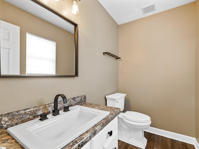 bathroom featuring vanity, hardwood / wood-style floors, and toilet