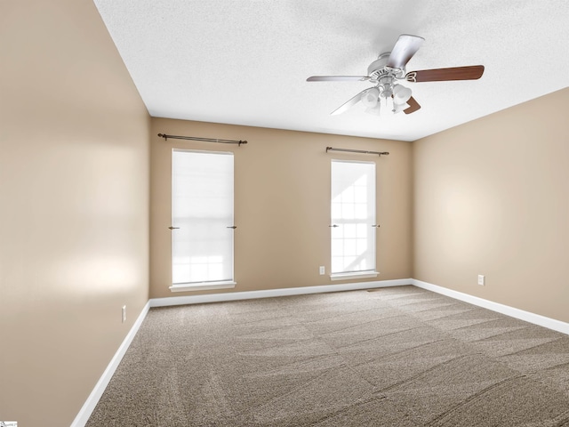 empty room featuring ceiling fan, carpet floors, and a textured ceiling