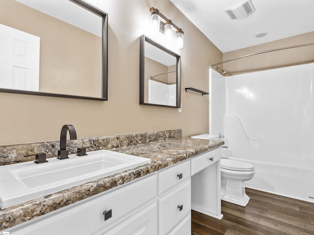 full bathroom featuring vanity, wood-type flooring, shower / washtub combination, and toilet