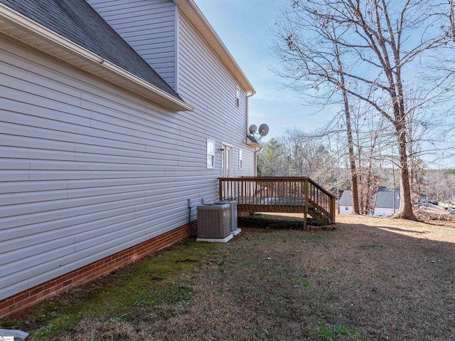 view of side of home featuring a lawn, central air condition unit, and a deck