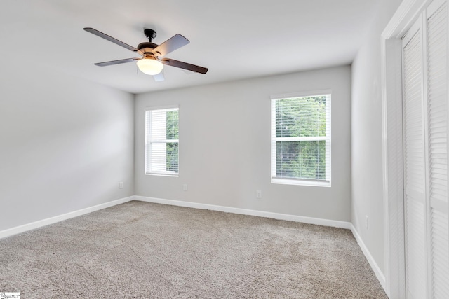 unfurnished room featuring ceiling fan and carpet