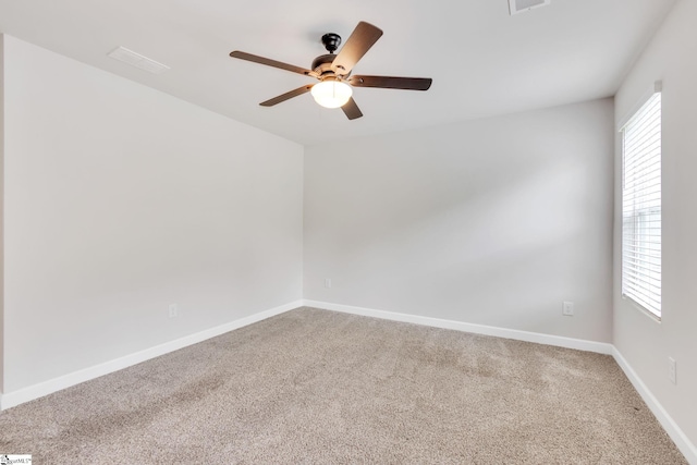 empty room with ceiling fan, plenty of natural light, and carpet