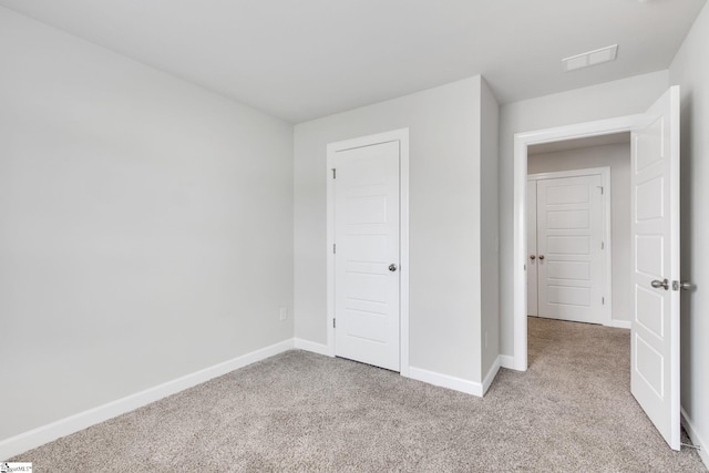 unfurnished bedroom featuring light carpet