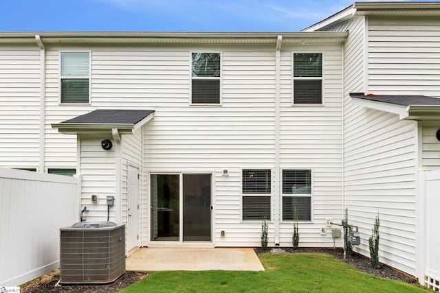 back of property with cooling unit, a yard, and a patio