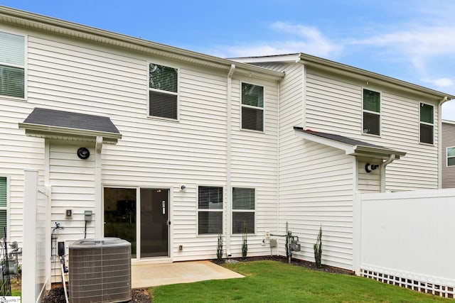 rear view of house with a patio area, central air condition unit, and a lawn