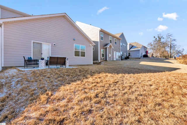 rear view of house featuring a yard and a patio