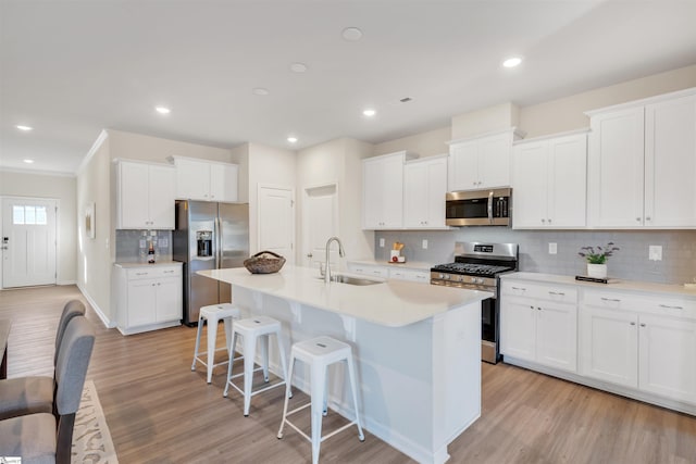 kitchen featuring white cabinetry, an island with sink, stainless steel appliances, and sink