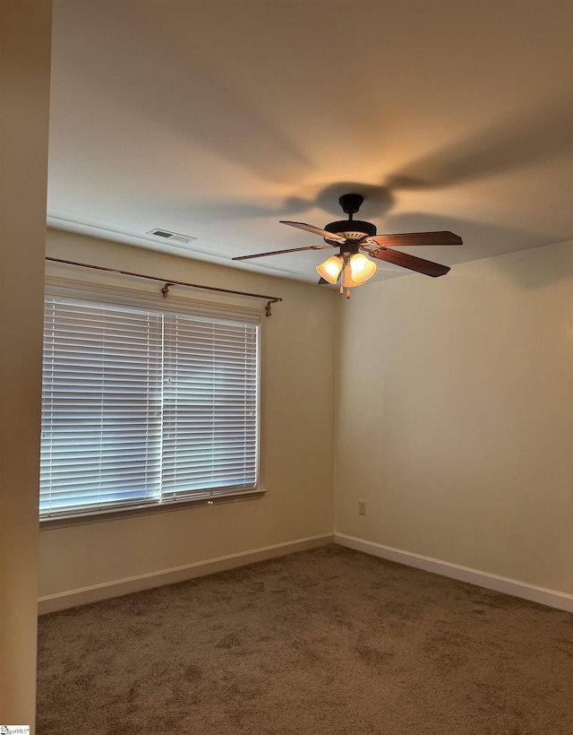 spare room featuring ceiling fan and dark colored carpet