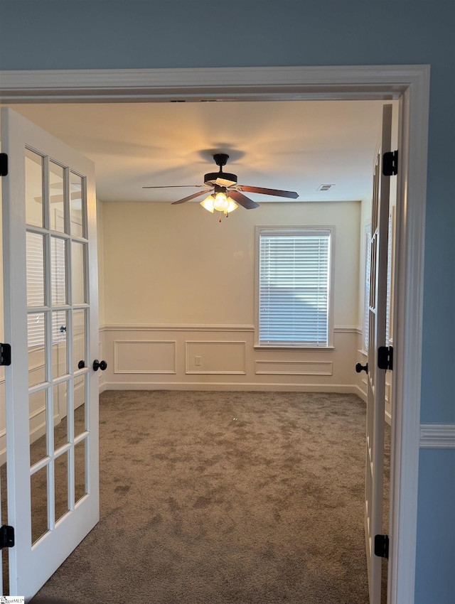 carpeted spare room featuring ceiling fan