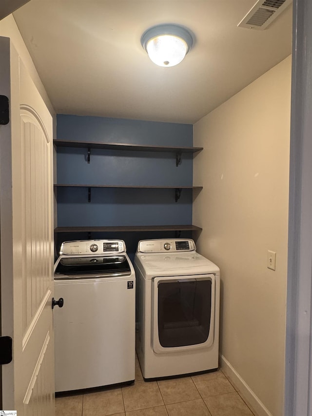 laundry area featuring washing machine and dryer and light tile patterned floors