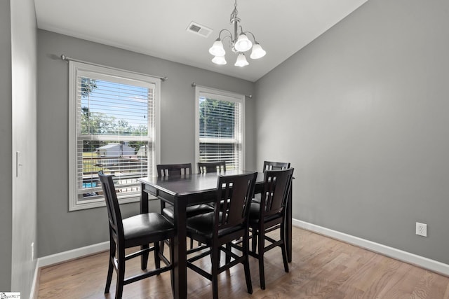 dining room featuring hardwood / wood-style flooring and an inviting chandelier