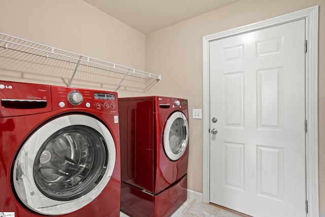 laundry room featuring washing machine and dryer and light tile patterned floors