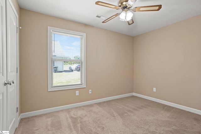 carpeted spare room with ceiling fan