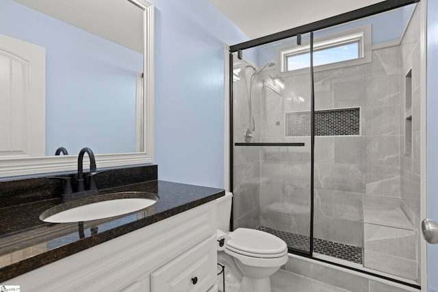 bathroom with vanity, toilet, and a shower with shower door