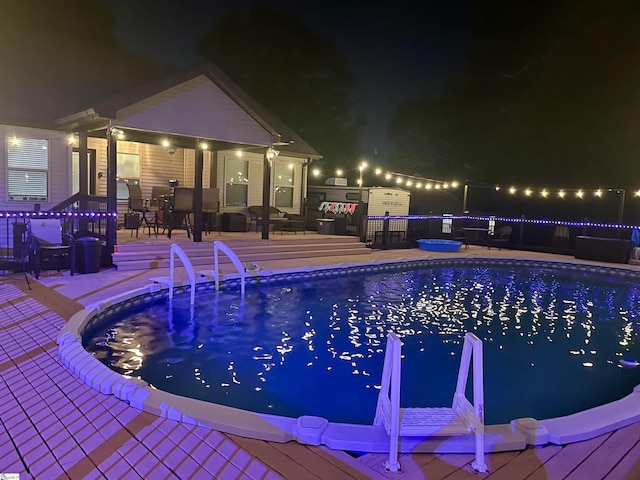 pool at twilight featuring a patio