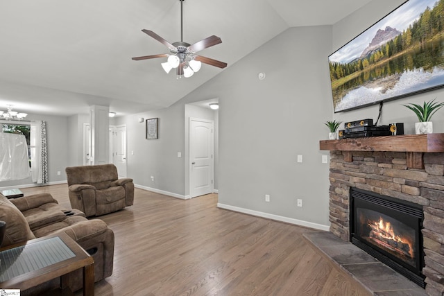 living room featuring ceiling fan, high vaulted ceiling, a stone fireplace, and hardwood / wood-style floors