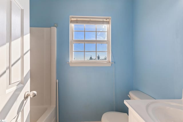 bathroom with a bathing tub, vanity, and toilet