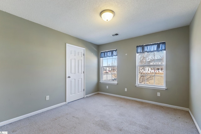 empty room with carpet flooring and a textured ceiling