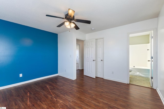 unfurnished bedroom with ceiling fan, connected bathroom, dark hardwood / wood-style flooring, and a textured ceiling