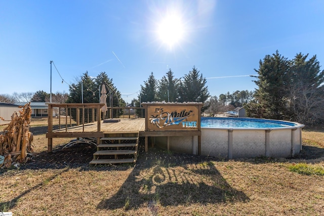 view of pool featuring a wooden deck and a lawn