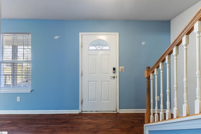 entryway featuring dark wood-type flooring and a textured ceiling