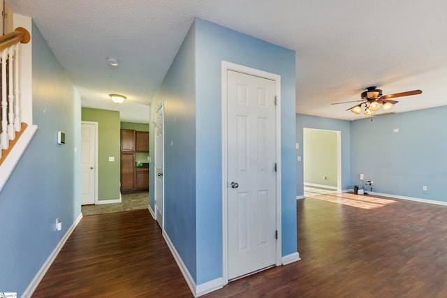 hallway with dark wood-type flooring and a textured ceiling