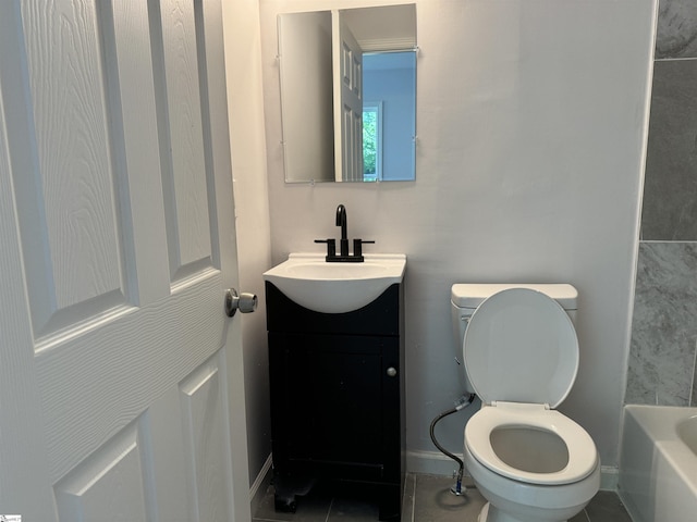 bathroom featuring tile patterned floors, vanity, toilet, and a bathtub