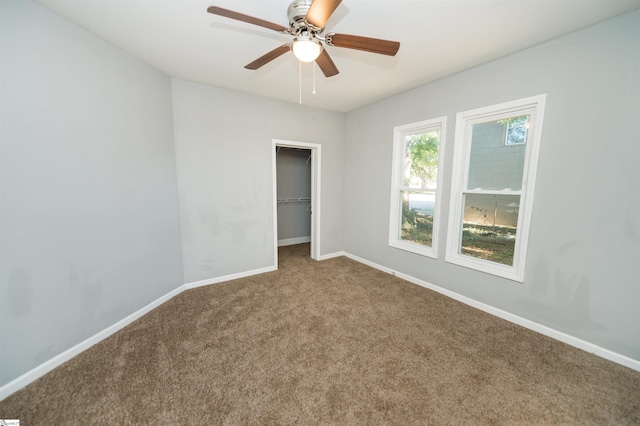 unfurnished room with ceiling fan and carpet