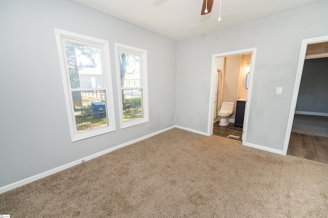 unfurnished bedroom with ensuite bathroom, ceiling fan, and carpet