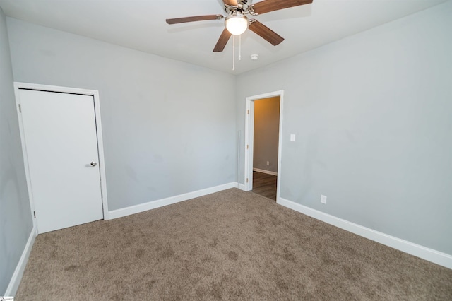 carpeted spare room featuring ceiling fan