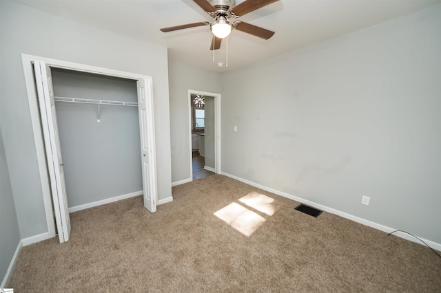 unfurnished bedroom featuring light colored carpet, ceiling fan, and a closet