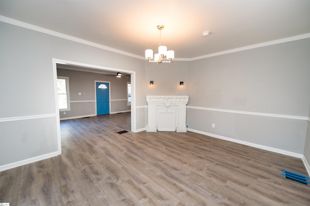 interior space featuring ornamental molding, ceiling fan with notable chandelier, and hardwood / wood-style floors