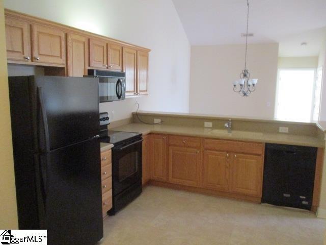 kitchen with decorative light fixtures, black appliances, sink, kitchen peninsula, and an inviting chandelier