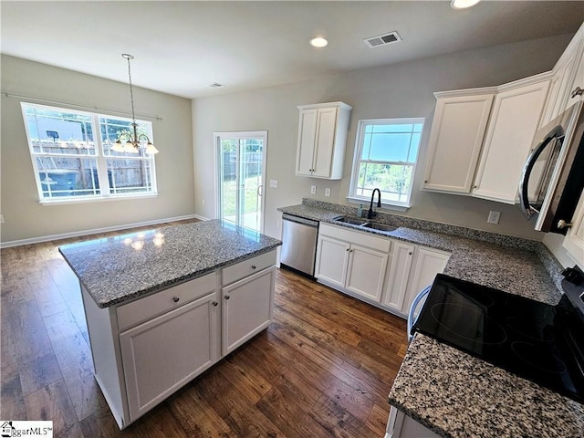 kitchen featuring a kitchen island, sink, white cabinets, stainless steel appliances, and dark wood-type flooring