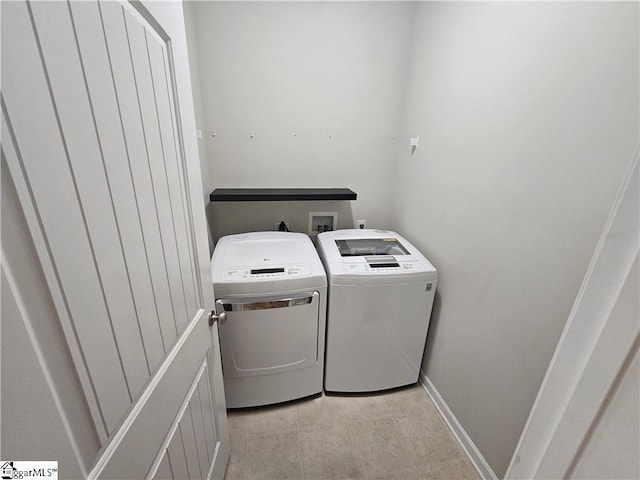 laundry area featuring light tile patterned floors and washing machine and dryer