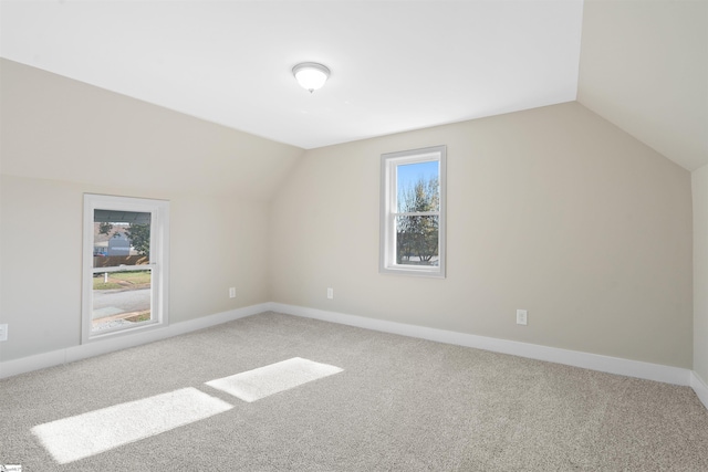 bonus room with vaulted ceiling and carpet