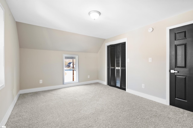 carpeted spare room featuring lofted ceiling