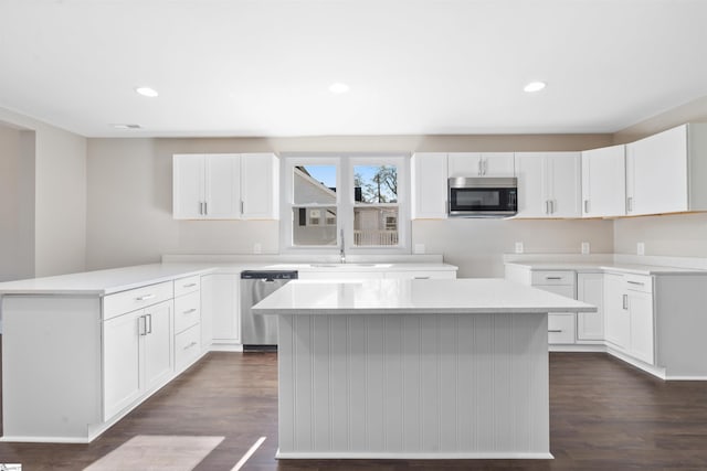 kitchen featuring white cabinetry, dark wood-type flooring, a center island, and appliances with stainless steel finishes