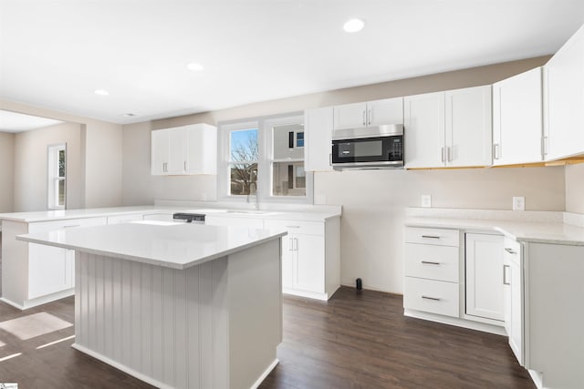 kitchen featuring white cabinetry, kitchen peninsula, dark wood-type flooring, and a kitchen island