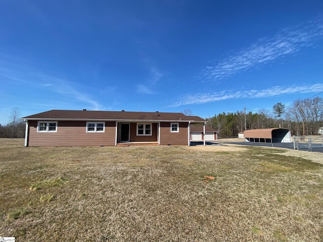 back of house featuring a lawn and a carport